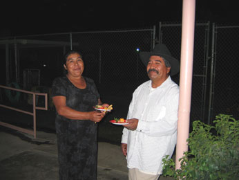 Photograph of Maria & husband outside Headstart with buffet plates in hand